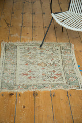 Oushak square rug featuring faded floral medallions, pastel colors, and exposed foundation.