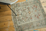 Oushak rug detail showing muted floral cross-sections, sea foam green border, and exposed foundation.