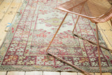 Vintage Anatolian rug with pale green field, red medallion, intricate floral patterns, and even wear.