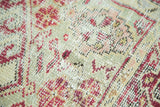 Close-up of vintage Anatolian rug's low pile, red floral motifs, and visible foundation.