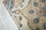Antique Kerman rug, revealing delicate floral vines, scalloped medallion, and foundation wear.