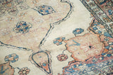 Antique Kerman rug detail: delicate floral motifs, vines, and softened pile.