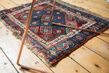 Antique Jaff Kurd rug's geometric lattice of sapphire blue, ruby red, and emerald green panels.