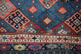 Detail of antique Jaff Kurd rug, showcasing geometric lattice panels and saturated jewel-tone borders.