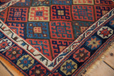 Angled view of an antique Jaff Kurd corner, highlighting the gem-tone lattice and sapphire border.