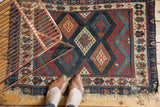 Antique Jaff Kurd geometric rug featuring lattice diamond panels in vivid madder, blue, ivory.