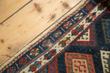 Antique Jaff Kurd rug corner detail: geometric borders with etched indigo, madder red pile.