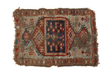 Antique Anatolian rug mat, cobalt blue medallion, red geometric patterns, aged wear, tattered edges.