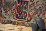 Antique Anatolian rug with intertwined cobalt blue medallion, red, beige patterns, and worn edges.