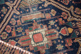 Fine antique Malayer rug detail: rectilinear serrated motifs in indigo, terra cotta, green, and wear.