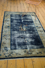 Antique Peking rug corner with worn cobalt blue field, ivory fruit and floral border, and fringe.