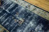 Worn cobalt blue field of the antique Peking rug with apricot floral ivory border detail.