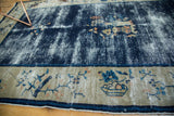 Antique Peking rug showing its storied cobalt blue field and ivory border with floral and fruit motifs.