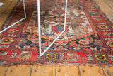 Antique Malayer rug with vivid red border and rich geometric patterns, showing time-worn patina.