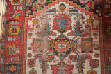 Detail of antique Malayer rug showing intricate geometric patterns, rich colors, and visible foundation.