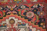 Section of antique Malayer rug with ivory geometric stepped design and colorful navy field florals.