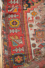 Detail of antique Malayer rug's fuchsia red border showcasing stylized motifs and distressed field.