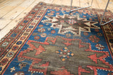 Vintage Caucasian rug's charcoal brown field with geometric patterns and exposed foundation.
