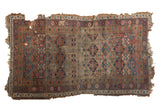 Antique Kurd rug, geometric lattice in faded indigo, red, and ivory with a beautifully tattered finish.