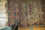 Tattered antique Kurd rug border showcasing pearl and geometric leaf patterns.