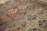 Detail of antique Kurdish rug's distressed lattice panels and unique meandering leaf border.