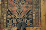 Antique Malayer rug with tattered edges, dramatic stepped medallion, and animal figures.