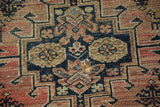 Antique tattered Malayer rug: a prominent hole in faded navy, blush, and beige patterned pile.
