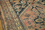 Tattered antique Malayer rug close-up: faded blush field, Mir boteh border, navy motifs.