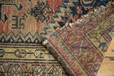Antique Malayer rug's tattered side, revealing geometric motifs and woven foundation.