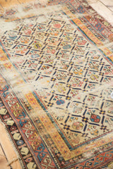 Close-up of the antique Shirvan rug's worn Marsali lattice with exposed foundation and faded tones.