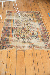Tattered fringe and exposed foundation on the worn edge of an antique Caucasian rug.