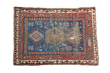 Antique Caucasian rug: indigo blue field, triple geometric medallions, madder red borders, areas of wear.
