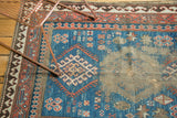 Holed areas visible on the blue field and medallion of this antique Caucasian rug.