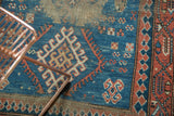 Antique Caucasian rug detail featuring hooked geometric motifs in indigo, terra cotta, and ivory.