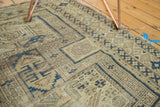 Antique Caucasian rug with geometric motifs in faded navy blue, sand, and ivory.