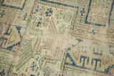 Geometric pattern and hand-knotted texture of an antique Caucasian rug in sand and navy blue.