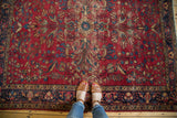 Vintage Persian Lilihan rug with cherry red field, blue and beige floral vinery, and feet.
