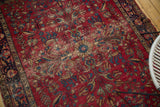 Vintage Lilihan rug's quatrefoil medallion, vinery, and floral patterns on a cherry red field.