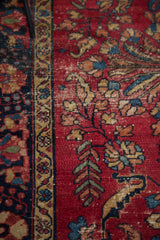 Vintage Lilihan rug with cherry red floral vinery and ornate navy, gold borders.