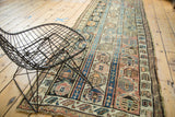 Faded geometric columns on antique Caucasian runner with mauve, orange, and seafoam tones.