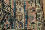 Detail of antique Caucasian runner's repeating geometric pattern in mauve, burnt orange, and blue.