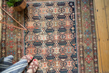 Shirvan rug's geometric crab motif, showing madder red, indigo, and ivory time-softened tones.