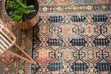 Geometric crab medallion motif with indigo, madder red, ivory, and sky blue hues on this antique Shirvan rug.