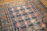 Antique Shirvan rug close-up: geometric crab motif in indigo, madder red, and ivory with wear.