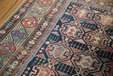 Aged texture reveals geometric border and crab medallions in rich madder red and indigo.