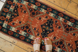 Contrasting geometric diamond medallions in navy and brick red on an Afghan Tent Cover rug.