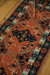 Vintage Afghan runner detail, terracotta field, dramatic navy elongated diamond medallion, geometric motifs.