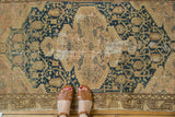Vintage Tajabad rug displaying faded tones, intricate serrated medallion, and overall wear.
