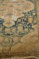 Vintage Tajabad rug close-up, revealing aged texture, blue serrated motifs, and a fringed edge.