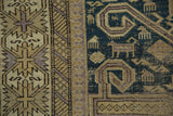 Antique Perpedil rug close-up: dusty teal rams horn motifs, geometric crab, and pawn borders.